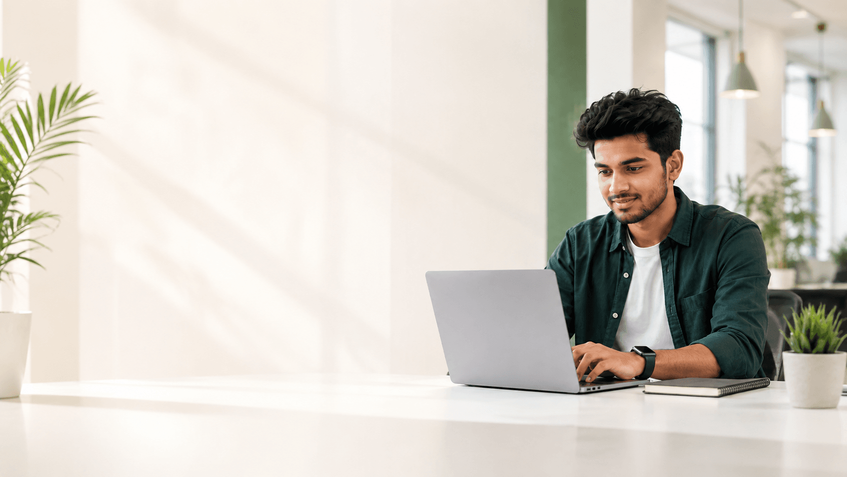 Young Indian student using a laptop during practical IT training